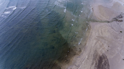 Small waves crashing on the sandy beach.