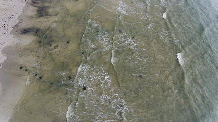 Small waves crashing on the sandy beach.