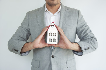 Businessman hands holding mock up house.