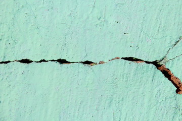 Cracked brick wall covered with cement. Background. Close-up.