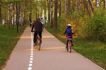 dad and daughter on bicycles in the Park