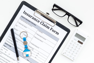 Real estate insurance. Insurance claim form near house keychain on white background top view