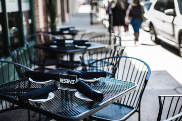Reserved sign on set restaurant table outside on the sidewalk 