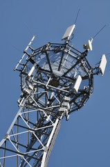 Top of telecommunication mast against blue sky