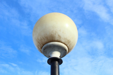 Street white round lighting lantern against the sky. Close-up.