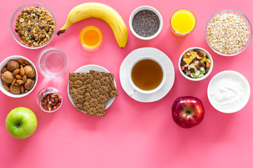 Obraz na płótnie Canvas Layout of products for healthy and hearty breakfast. Fruits, oatmeal, yogurt, nuts, crispbreads, chia on pink background top view copy space