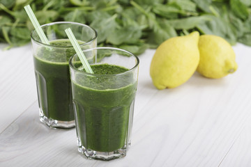 Spinach with lemon juice a soft drink jar with straw on white wooden table
