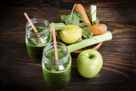 Spinach with apple and vegetables juice a soft drink jar with straw on wooden table