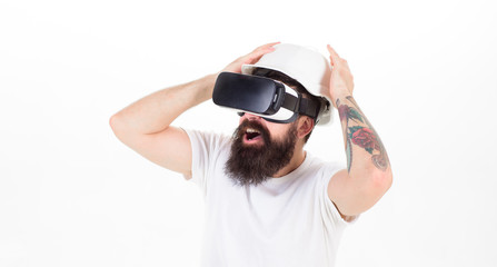 Man with long beard in VR glasses having frightening experience, virtual reality concept. Brutal builder with beard in safety helmet isolated on white background. Bearded man shouting out of fear