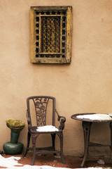 Cast Iron Chair and Table Under A Decorative Window Covering, Santa Fe, New Mexico