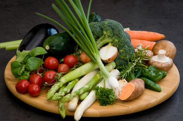Wooden plate with fresh  colorful  various vegetables on a dark background