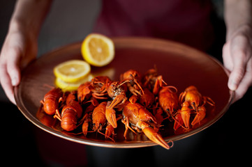 girl holding a dish of boiled crayfish. Seafood. Mediterranean food.