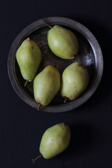 Pears in a plate on a black background