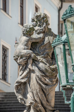 Statue of old priest with baby at Old Town in Prague, Czech Republic