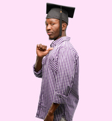Young african graduate student black man proud, excited and arrogant, pointing with victory face