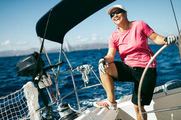 Happy strong woman sailing with her boat