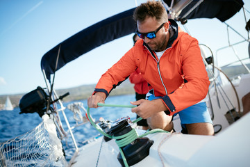 Handsome strong man sailing with his friends