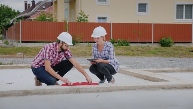Quality control inspector with an assistant check the accuracy of the work on the erection of the foundation