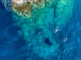 Aerial drone view of snorkelers with huge oceanic manta rays