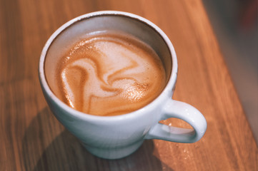 Top view of hot coffee cappuccino latte in white ceramic cup on marble table. Coffee cup top view on old wooden. Coffee cup in coffee shop