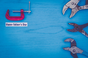 Happy Father's Day still life concept with worn tools on blue board, flat lay in vintage setting