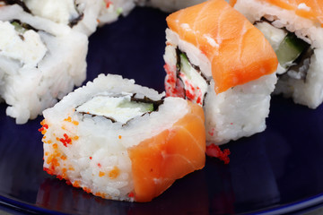 Sushi is very close-up on a dark blue background. Sushi with fish. A beautiful photo of food.
