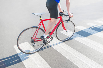 Fototapeta na wymiar Cyclist rides a zebra on a red road bike. Riding a city on a bike. Sports concept.