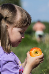 Little girl holding a ruddy apple