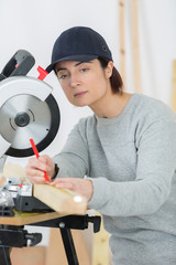 woman carpenter using circular saw