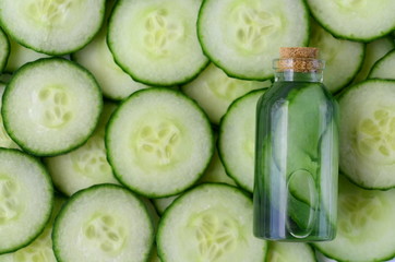 Fresh cucumber slices and natural beauty face toner in a glass bottle with copy space. SPA and beauty concept.
