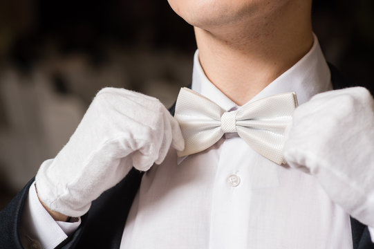 Gentleman touch his white tie bow