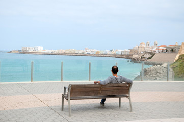 Mann blickt auf die Altstadt von Cadiz, Andalusien 