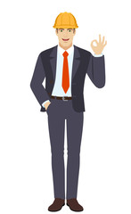 OK! Businessman in construction helmet with hand in pocket showing a okay hand sign