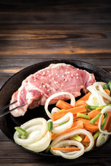 Raw pork chop marinated meat roll with assorted vegetables