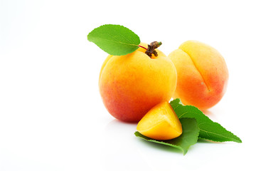 Ripe, juicy and appetizing apricot fruit with green leaves close-up, isolated on white background