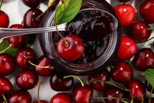 Rustic jar with cherry jam and fresh cherries, homemade preserves