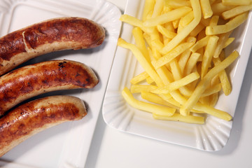 Grilled sausage served with french fries or fried potatoes with sausage