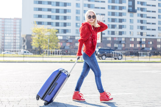 Young cheerful woman with a suitcase. The concept of travel, work, lifestyle. - Powered by Adobe