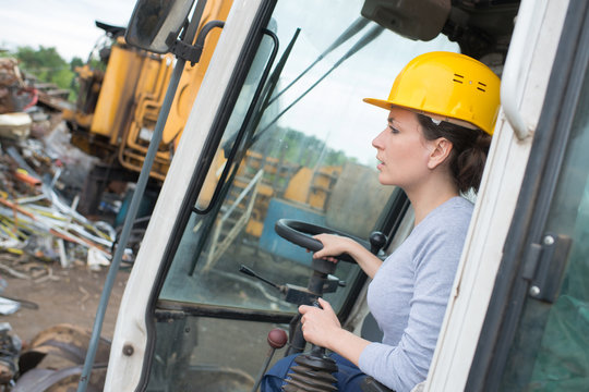female worker operating forklift truck in shipping yard