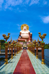 Wat Plai Laem temple with giant fat laughing Buddha statue and golden rooster statues in foreground, Koh Samui, Thailand