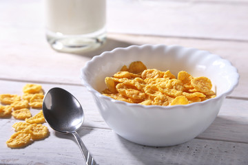 Corn Flakes cereal in a bowl and glass with milk. Morning breakfast.