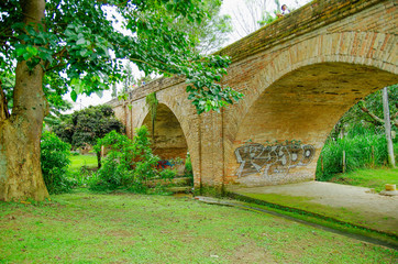 Fototapeta na wymiar Outdoor view of brick bridge of Humilladero located in the forest surrounding of nature in colonial city Popayan