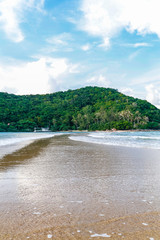 View of Koh Ma island during a sunny day from a tropical Mae Haad sandy beach with sandy path leading towrds the island, Koh Phangan, Thailand