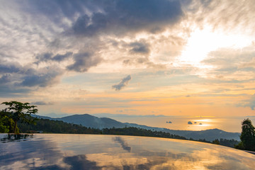View of the ocean and nearby islands with a swimming pool in the foreground before sunset, Koh Samui, Thailand