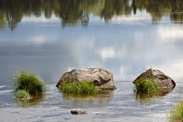 Fototapeta na wymiar Three big stones in a flowing river