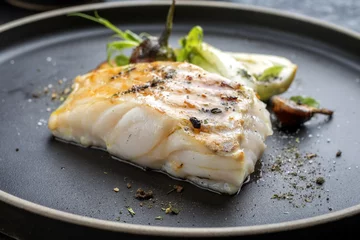 Foto op Plexiglas Vis Moderne Thaise gebakken kabeljauwfilet met paksoi en champignons van dichtbij op een bord