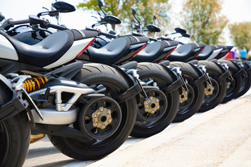 Row of the motorcycles on test drive on street