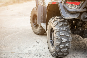 Close-up tail view of ATV quad bike. Dirty whell of AWD all-terrain vehicle. Travel and adventure concept.Copyspace.Toned © Kirill Gorlov