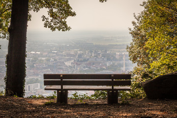 a bench with a aerial view of Heidelberg town in Germany