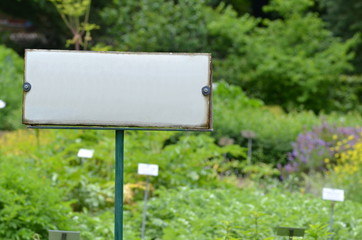 White sign in a garden with space for text